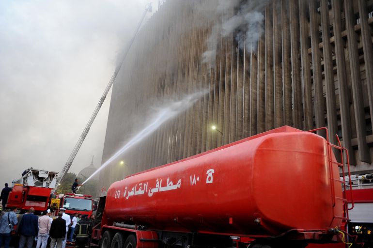 Firefighters douse the flames after a fire broke out in the Telephones landline exchanging station and Ministry of Communications building in the heart of Cairo on July 7, 2025.