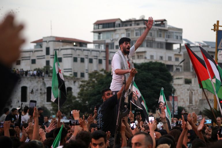 TOPSHOT - People take to the streets of Hama to protest against Israeli intervention in Syria, on July 16, 2025.
