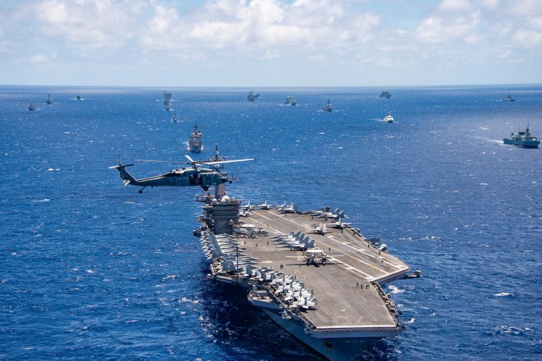 FILE -- In this July 26, 2018, file photo provided by the U.S. Navy, the aircraft carrier USS Carl Vinson participates in a group sail during the Rim of the Pacific exercise off the coast of Hawaii. Hawaii's governor says he will ask the U.S. military to postpone the world's largest maritime exercises because of the coronavirus pandemic. (Petty Officer 1st Class Arthurgwain L. Marquez/U.S. Navy via AP, File)