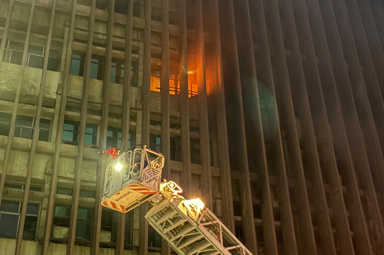 Fire fighters battle flames after a fire broke out in a telecommunications building in central Cairo, Sunday, July 7, 2025. (AP Photo/Ahmed Hatem)