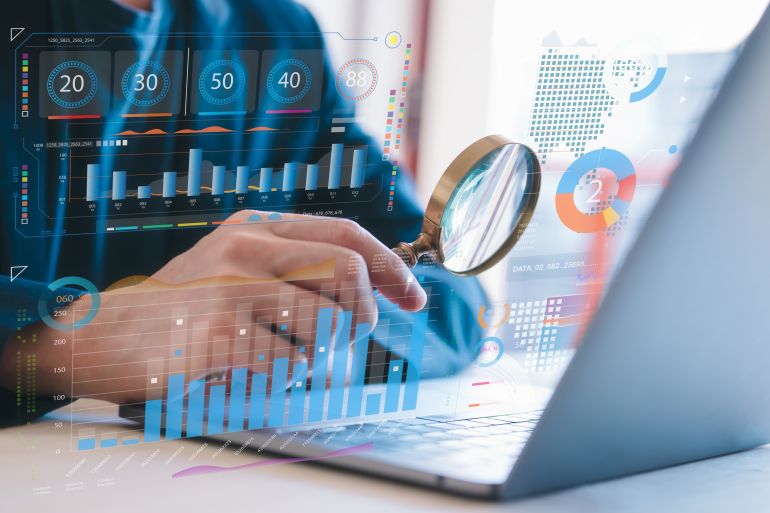 businessman holding magnifying glass looking at virtual data chart dashboard in concept of investment data analysis and DMS document audit financial Tax Fraud audit Using Magnifying Glass; Shutterstock ID 2504233183; purchase_order: aljazeera ; job: ; client: ; other: