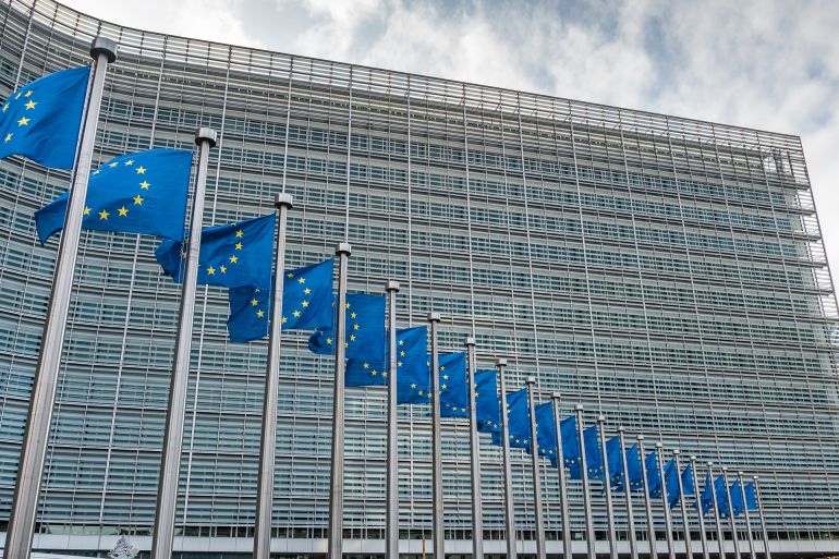 European Union flags waiving in front of Berlaymont building of the European Commission, Brussels, Belgium