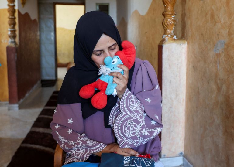 Palestinian mother Iman Al-Nouri, who lost two of her children, Omar and Amir, in the July 10 Israeli strike while they were queuing for supplements near a medical center, kisses a soft toy belongings to her son Siraj, who was wounded in the same strike and is being treated at Al-Aqsa Martyrs Hospital, at her home in Deir al-Balah, in the central Gaza Strip, July 15, 2025. REUTERS/Ramadan Abed TPX IMAGES OF THE DAY
