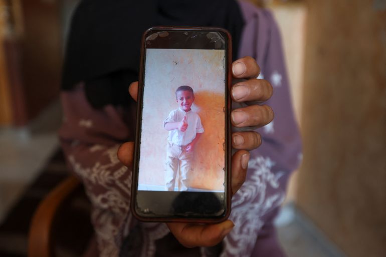 Palestinian mother Iman Al-Nouri shows a picture of her son Amir, who was killed along with his brother Omar in the July 10 Israeli strike while they were queuing for supplements near a medical center, as Iman's son Siraj, who was wounded in the same strike, receives treatment at Al-Aqsa Martyrs Hospital in Deir al-Balah, in the central Gaza Strip, July 14, 2025. REUTERS/Ramadan Abed