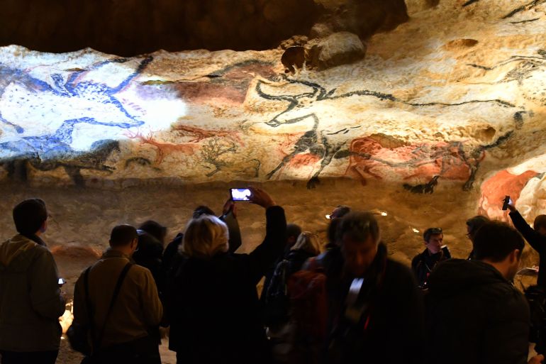 Visitors take pictures during the inauguration of the new museum Lascaux 4 on December 10, 2016, in Montignac, south western France. The international Center of cave art in Montignac (Le Centre international d'art parietal de Montignac) displays a new replica of the prehistoric paintings of the famous Lascaux cave, named the Lascaux 4.