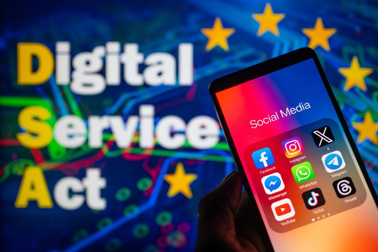 Social media icons logo displayed on a smartphone with European Commission Digital Service Act on screen seen in the background, in this photo illustration. On 19 October 2023, in Brussels, Belgium.