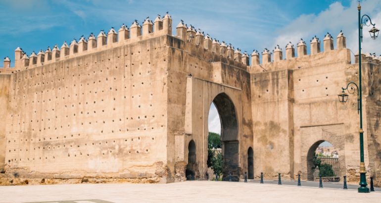 The impressive Bab Mahrouk gate in Fez, with its rammed-earth walls, crenellations, and historic arched openings.