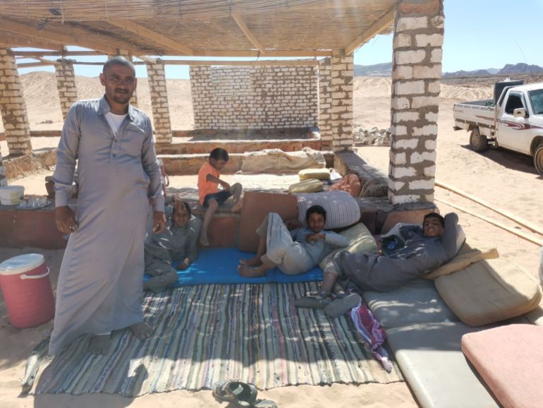 بدوي ينتظر فوج سياحي لنقله بسيارة دفع رباعي إلى قلب الصحراء