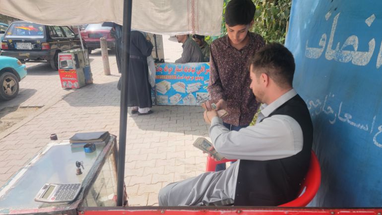 صرّاف أفغاني يتعامل مع أحد العملاء في أحد أسواق كابل حركة يومية تعكس اعتماد المواطنين المتزايد على الصرافة التقليدية وسط أزمة ثقة بالبنوك