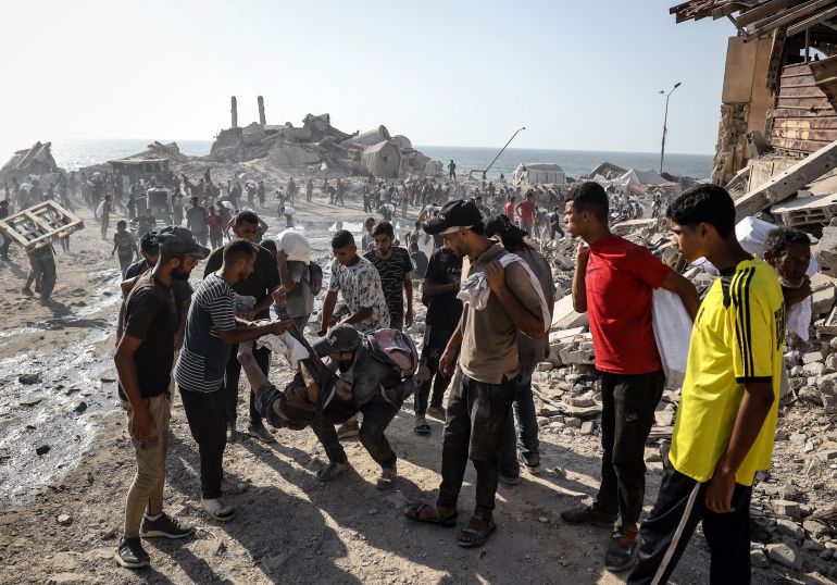 GAZA CITY, GAZA - AUGUST 2: Palestinians carry the bodies after the Israeli forces opened fire on Palestinians waiting for humanitarian aid in the northern Gaza area of Zikim Crossing in Gaza City, Gaza on August 2, 2025. Survivors and witnesses rushed to evacuate the wounded and the dead from the area. ( Khames Alrefi - Anadolu Agency )