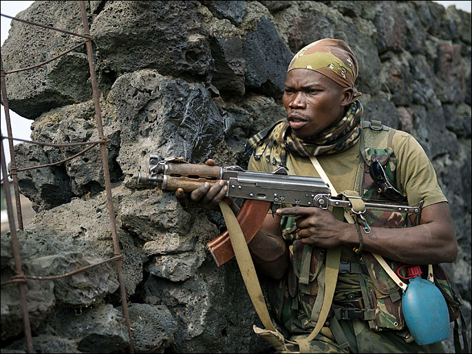 A Congolese army soldier takes position behind a wall during a fire-fight in Kanyarucinya, around 10km from Goma in the east of the Democratic Republic of the Congo on July 17, 2013. Heavy fighting resumed this afternoon, with artillery shelling and small arms combat in Kanyarucinya, and to the north, around Kibati. AFP PHOTO/PHIL MOORE