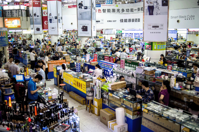 People sell goods at a shop in the Huaqiangbei electronics market in Shenzhen,