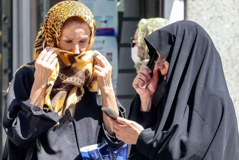A woman browses a phone while standing along a street in Tehran on September 10, 2023. Iranian authorities have blocked popular social media networks, including Instagram and WhatsApp since mass protests erupted following the September 2022 death in police custody of 22-year-old Iranian Kurd Mahsa Amini. The restrictions come as millions of Iranians struggle to make ends meet, grappling with in an economic crisis marked by crippling Western sanctions, a galloping inflation, and sharp decline of the local currency. (Photo by ATTA KENARE / AFP) (Photo by ATTA KENARE/AFP via Getty Images)