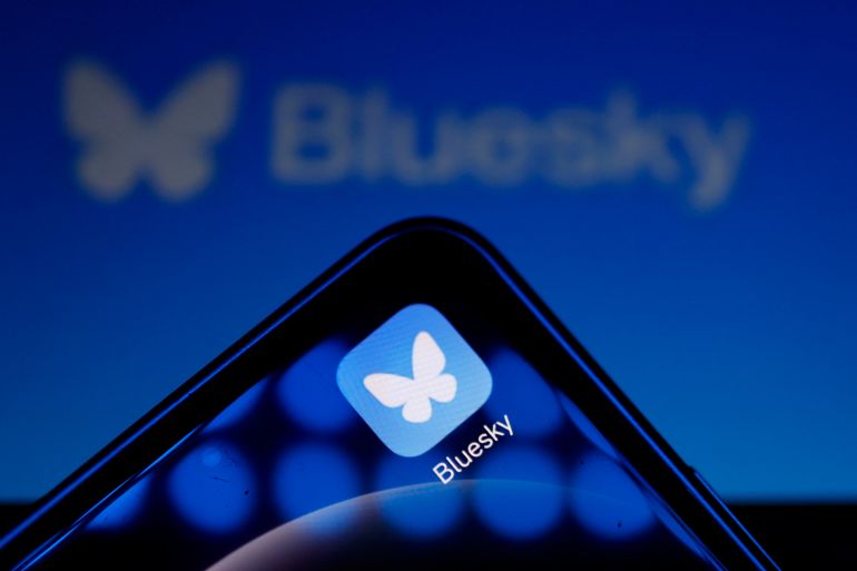 This illustration photograph taken on November 12, 2024, shows the logo of social media platform Bluesky displayed on a mobile telephone and tablet, in Paris. - The bluesky social network has soared to one of the top positions in social network downloads in app stores in the past week since the US election. The company reported a recent gain of 700,000 new users joining the social media platform, an alternative to X (formerly known as Twitter). (Photo by Ian LANGSDON / AFP)