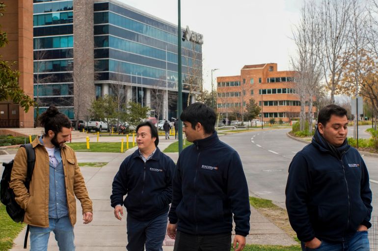Actor Sebastián Solorza, who has Down syndrome and aims to run for president as an independent candidate, walks with coworkers in Santiago, Chile, Thursday, July 31, 2025. (AP Photo/Esteban Felix)
