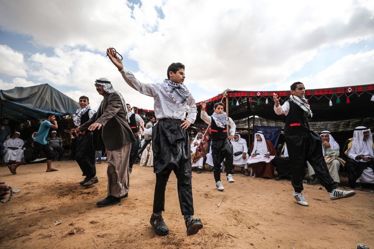 KHAN YUNIS, GAZA - OCTOBER 10: Palestinians perform a traditional folk dance called 'Dabke' at the "Great March of Return" demonstration area during an event, based on Palestinian cultural legacy, organised by a Palestinian committee in Khan Yunis, Gaza on October 10, 2018. (Photo by Mustafa Hassona/Anadolu Agency/Getty Images)