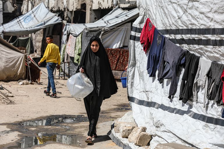 GAZA CITY, GAZA - MARCH 27: Palestinians wait for water distribution in Gaza City, Gaza, on March 27, 2025. Palestinians in the city struggle to meet their water needs by filling jerrycans with water distributed via tankers. Israel's blockade on fuel entry through the Kerem Shalom border crossing has disrupted electricity supply to water purification facilities, further exacerbating the water crisis in the region. (Photo by Dawoud Abo Alkas/Anadolu via Getty Images)