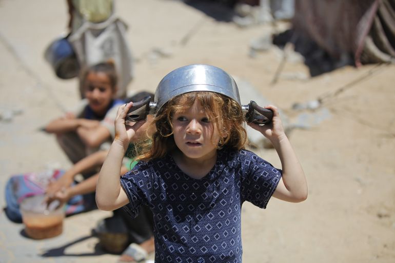 DEIR AL-BALAH, GAZA - JUNE 02: A Palestinian child is seen waiting with an empty pot as charitable organizations distribute hot meals to Palestinians in Nuseirat refugee camp, who are struggling with hunger due to Israel's attacks on Gaza and closed borders in Deir al-Balah, Gaza, on June 02, 2025. As Israel's relentless and devastating attacks on the Gaza Strip continue, Israeli policies have exacerbated the already severe humanitarian crisis in the region. (Photo by Moiz Salhi/Anadolu via Getty Images)