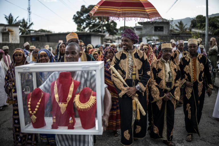 TOPSHOT - Porters carry display cases containing the gold dowery that Franco Comoran Faid Kassime (C), who lives with his wife Faizat Aboubacar in Reunion, will bring to his bride family home in Moroni on July 20, 2025 during the Grand Mariage ceremony.