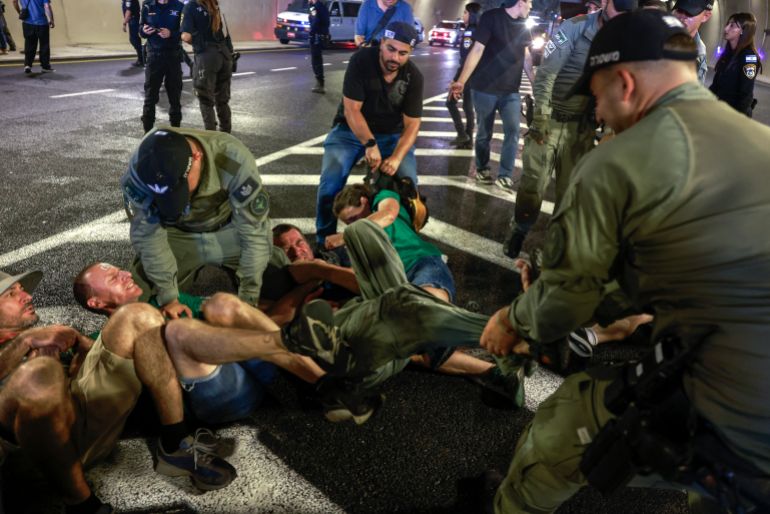 TOPSHOT - Israeli police remove demonstrators blocking traffic in a tunnel, as families and supporters of Israelis held hostage by Hamas militants in Gaza since the October 7, 2023 attacks, stage a protest calling for government action to secure their release in Jerusalem on August 17, 2025.