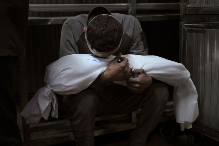 Hossam Azzam holds the body of his son Amir who was killed in an Israeli military airstrike on Gaza, at Shifa Hospital in Gaza City, July 15, 2025. (AP Photo/Jehad Alshrafi)