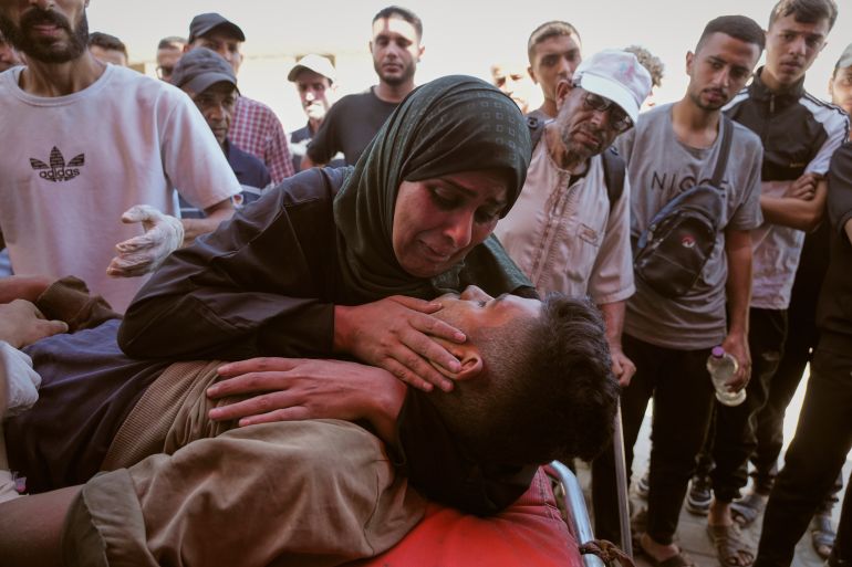 Nabila Al Shaer, center, mourns the body of her son, Jamil Al Shaer, 21, who was killed while trying to receive aid from the U.S.-backed Gaza Humanitarian Foundation (GHF) in Netzarim, in the central Gaza Strip, at Al-Aqsa Hospital, Thursday, July 31, 2025.(AP Photo/Abdel Kareem Hana)