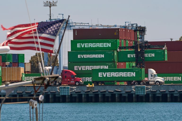 Shipping containers sit stacked at the Evergreen terminal at the port of Los Angeles, Friday, Aug. 1, 2025. (AP Photo/Damian Dovarganes)