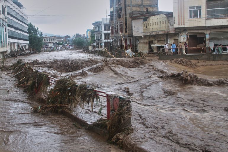 Local residents look at flash flooding due to heavy rains in a neighborhood of Mingora, the main town of Swat Valley, northwestern Pakistan, Friday, Aug. 15, 2025. (AP Photo/Naveed Ali)