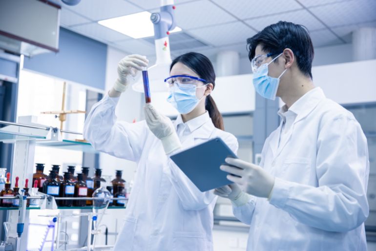 Asian scientists using a digital tablet in a medical laboratory