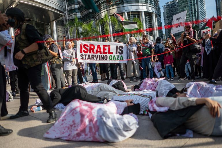 epa12279262 Protesters lie on the ground during a rally titled 'March for Gaza' in Kuala Lumpur, Malaysia, 02 August 2025. More than a thousand people joined the peaceful demonstration, part of a global movement calling on Israel to immediately end the use of starvation as a weapon of war. EPA/NAZIR SUFARI