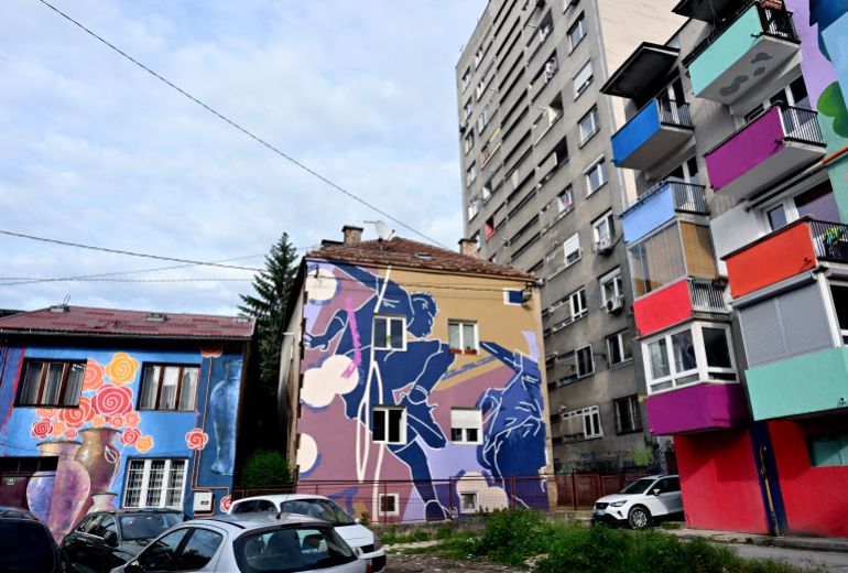 A photo shows the facades of old buildings renovated with murals by Bosnian street artist Benjamin Cengic and his creative team in Sarajevo on May 22, 2025. (Photo by ELVIS BARUKCIC / AFP)
