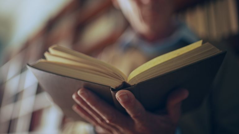 An educated man reading in a library