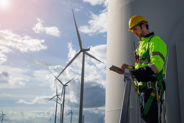 engineers are discussing maintenance of wind turbines. Clean energy. Alternative energy concept; Shutterstock ID 2340726169; purchase_order: aj; job: ; client: ; other: