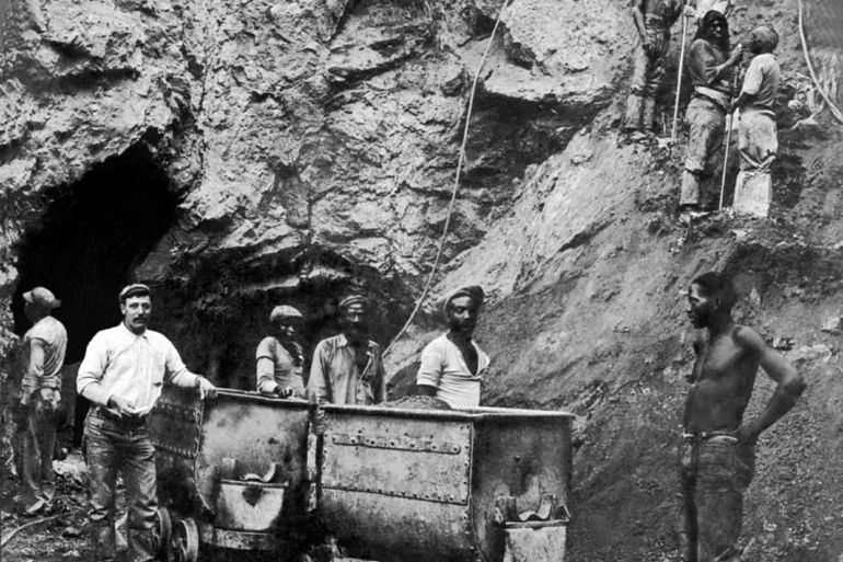 Miners stand by two mine cars on their track at one of the De Beers mines, Kimberley, South Africa, early 20th Century. (Photo by FPG/Getty IMages)