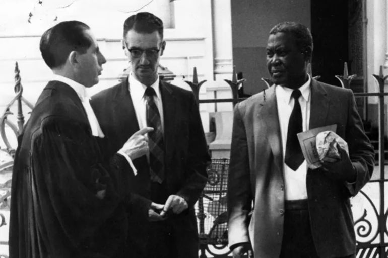 Sydney Kentridge, one of the defence lawyers at the Treason Trial, which accused 156 people, including Nelson Mandela, of treason, and lasted from 1956 to 1961, speaks to a special branch man and Chief Luthuli outside the Old Synagogue in South Africa [Sunday Times/Gallo Images/Getty Images]