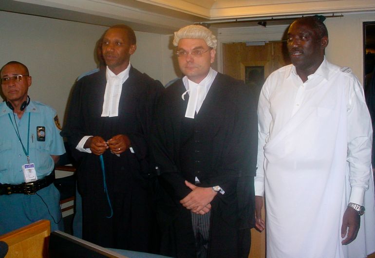 Former top Rwandan artist Simon Bikindi (R) stands before the International Criminal Tribunal for Rwanda (ICTR) in Arusha December 2, 2008. A U.N. court trying the masterminds of Rwanda's 1994 genocide gave a 15-year jail sentence on Tuesday to a famous musician who used a public address system to incite the killing of ethnic Tutsis. The Tanzania-based ICTR found Bikindi, 54, guilty of direct and public incitement to commit genocide. REUTERS/Hirondelle News Agency/Handout (TANZANIA)
