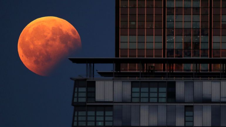 A partial lunar eclipse is pictured beside a building in Berlin, Germany, August 7, 2017. REUTERS/Hannibal Hanschke