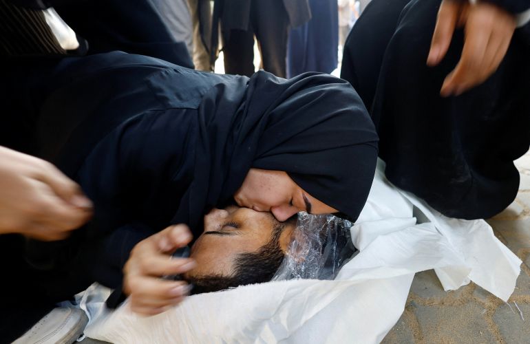 SENSITIVE MATERIAL. THIS IMAGE MAY OFFEND OR DISTURB A mourner reacts next to a body during the funeral of Palestinians who were killed by Israeli fire while trying to receive aid and another killed in a strike on Friday, according to medics, at Al-Shifa Hospital in Gaza City, August 30, 2025. REUTERS/Mahmoud Issa