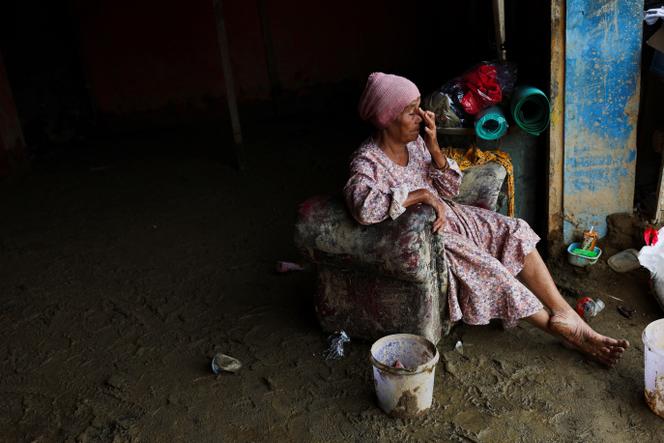 الناجية روزمانيا ناسوتيون، 70 عامًا، تأخذ استراحة بعد جمع البضائع القيمة من متجر البقالة الخاص بها، في أعقاب الفيضانات القاتلة التي ضربت سومطرة، في باتانج تورو، إندونيسيا، في 6 ديسمبر 2025. 