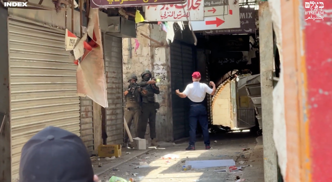 نضال عميرة (40 عاما) يقترب من جنديين إسرائيليين مسلحين، في مقتطف من مقطع فيديو استقصائي لمنظمة بتسيلم الإسرائيلية غير الحكومية خلال عملية للجيش في نابلس، 10 يونيو، 2025. 