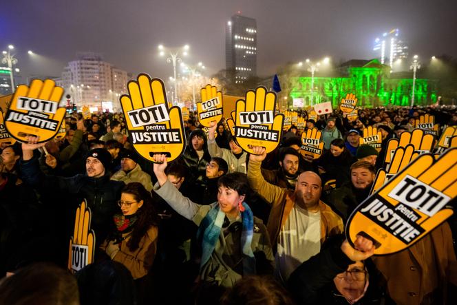 متظاهرون يحملون لافتات كتب عليها “الكل من أجل العدالة” خلال تجمع أمام مقر الحكومة الرومانية للمطالبة بإصلاح النظام القضائي، في بوخارست، 12 ديسمبر 2025.